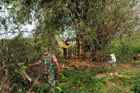 Babinsa Kelurahan Bence Ajak Warga Bersihkan Ranting Bambu Yang Menutu